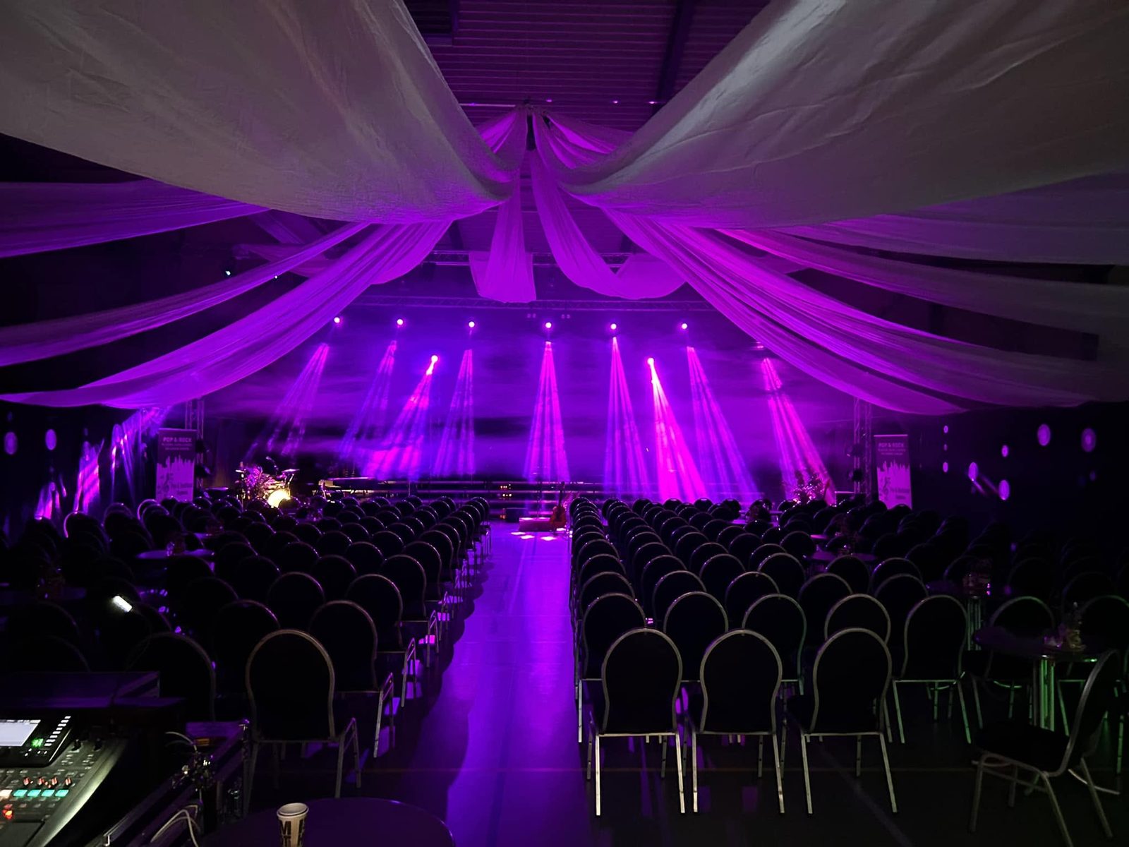 De zaal ingericht voor een concert met podium en sfeerverlichting